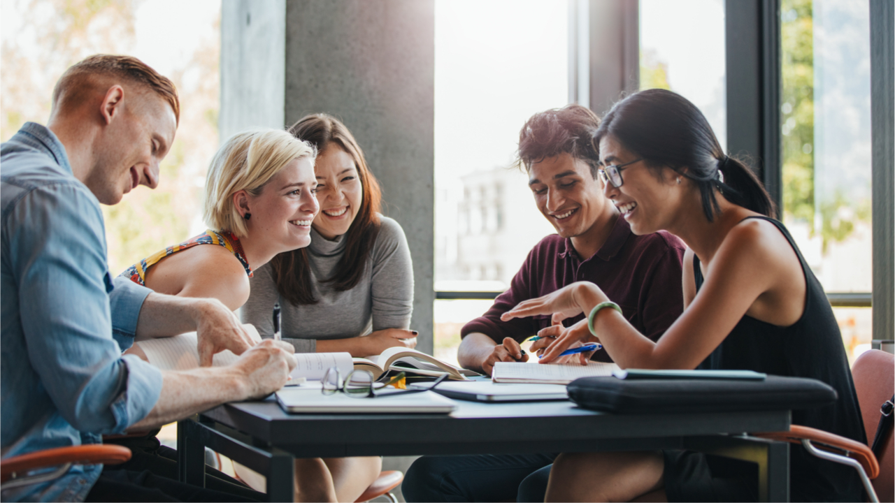 Happy students gathered around a table.