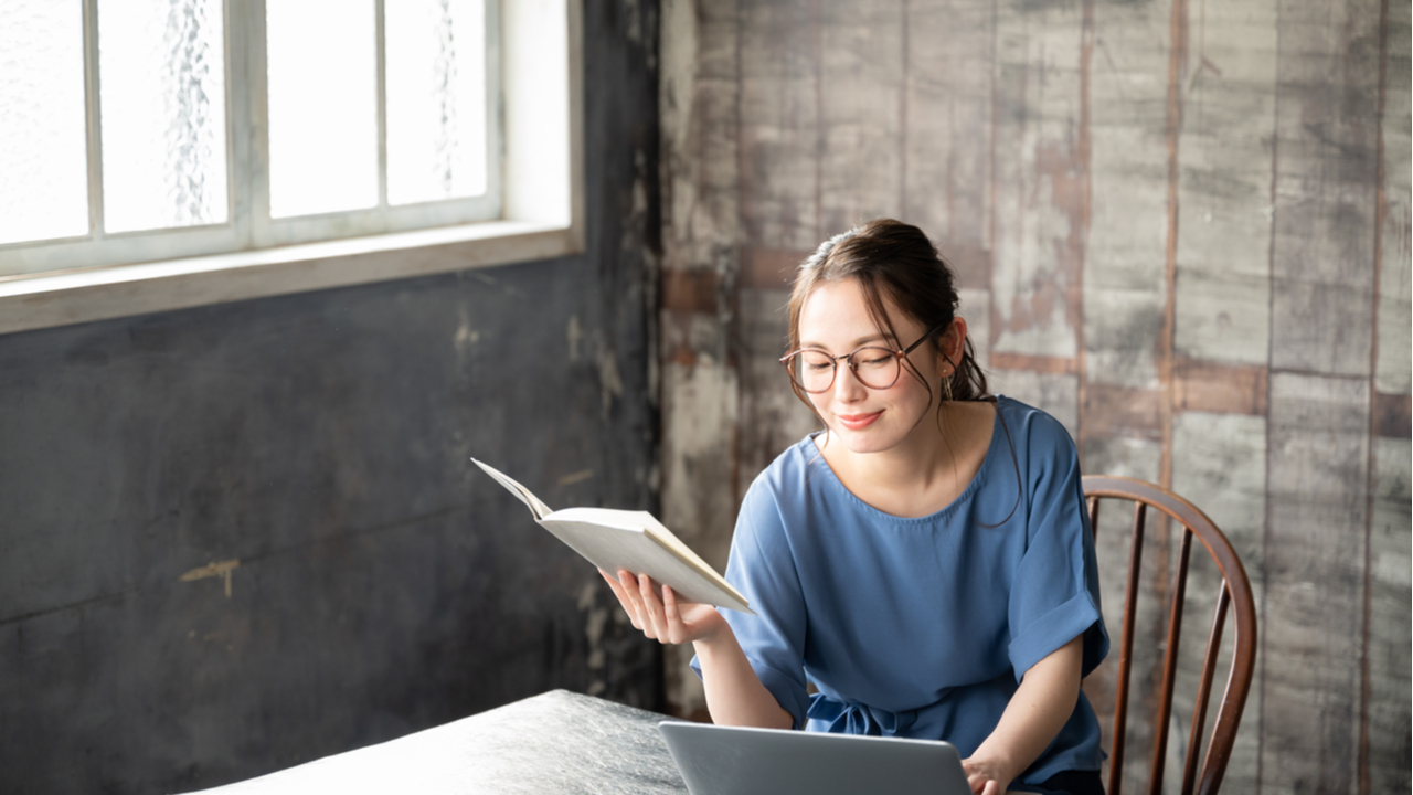 Woman with a book and a laptop