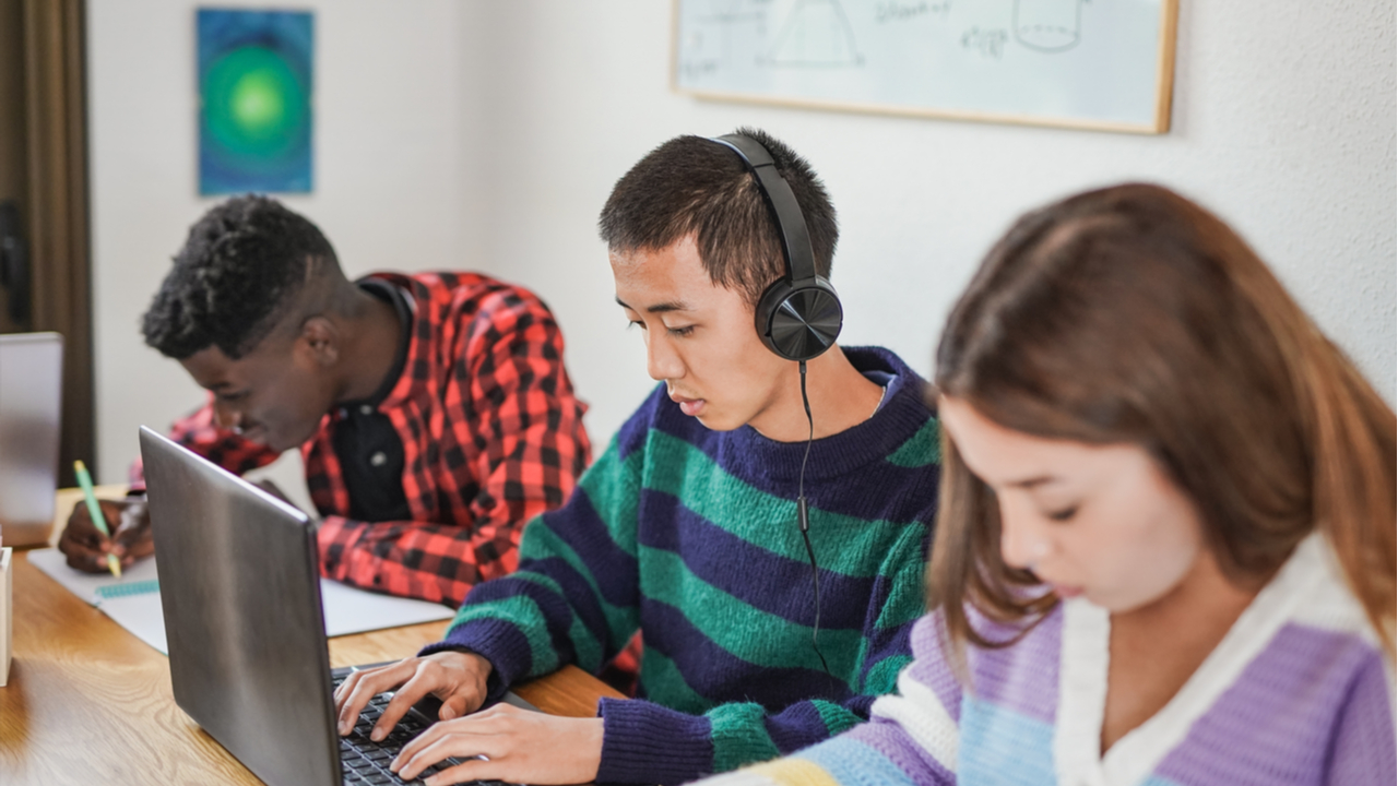 multiracial students learning together inside library