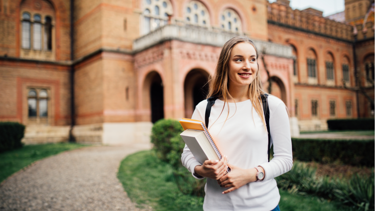 Woman in front of gothic college building